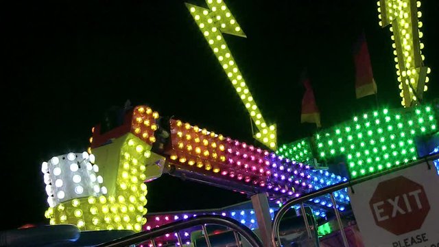 A wide angle perspective shot of a ride at an amusement park at night.
