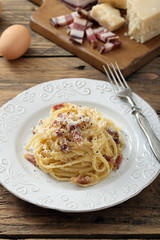 pasta carbonara  con uova carne e formaggio sfondo tavolo di cucina rustico