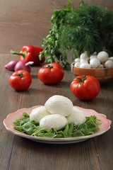 mozzarella formaggio fresco con pomodori e verdure sfondo tavolo di cucina rustico