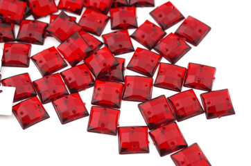 Crimson-red rhinestone on white background