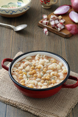 zuppa di pasta e ceci in tegame di metallo sfondo tavolo di cucina rustico