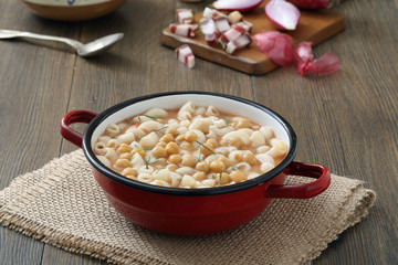 zuppa di pasta e ceci in tegame di metallo sfondo tavolo di cucina rustico