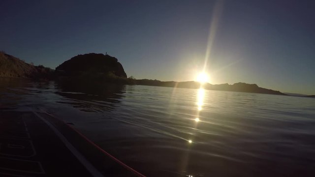 A wide angle view from a boat beached on lake shore at sunset.