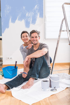  Handsome couple painting walls of their new home