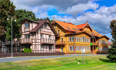 Fototapeta na wymiar Traditional Lithuanian wooden and half-timber houses in the countryside. Juodkrante village, Lithuania.