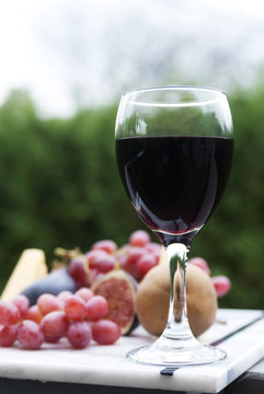 Close-up of red wine served with fruit platter