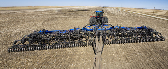 An air seeder and tractor in a field with blue sky,Alberta Canada