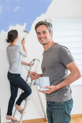  Handsome couple painting walls of their new home