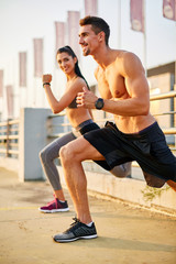Young couple exercising and stretching muscles before sport activity - outdoor