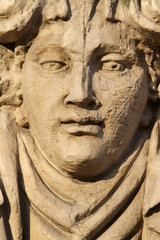 Fototapeta na wymiar Sculpture d'un visage en pierre.