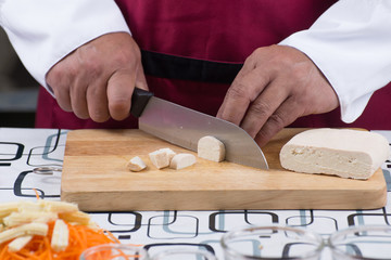 Chef slicing tofu for cooking