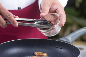 Chef putting mushroom  to the pan