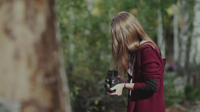 Girl with rarity camera walks in the woods. The girl with the camera in the woods of the old model. A girl in a burgundy cardigan pictures of duck