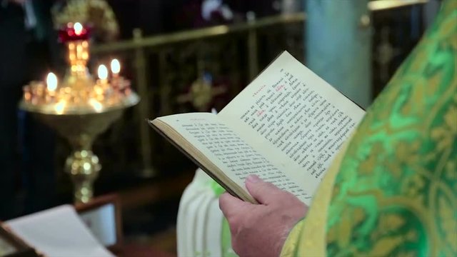 Priest reading the Bible in church. priest shatters the scriptures holy bible
