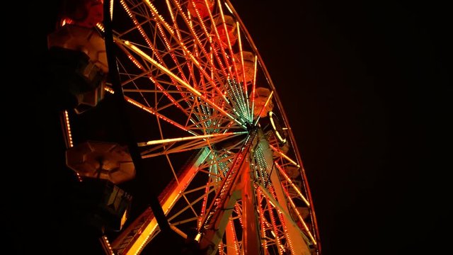 A ferris wheel spins in the night.