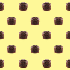 Seamless Pattern Of Sweet Chocolate Muffins On Pastel Yellow Background