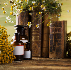 Herbal medicine and book on wooden table background