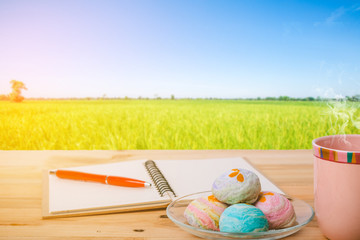 coffee cup on wood table with rice field background