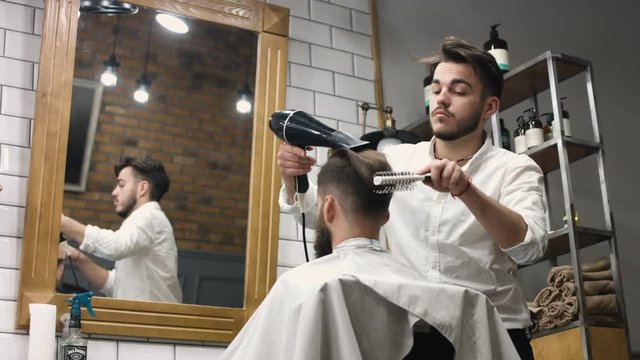 A man looks into a mirror after having his beard groomed at a barber shop. Shot on RED Epic in slow motion.