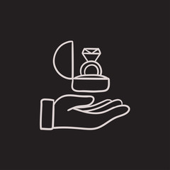 Hand holding gift box with ring sketch icon.
