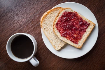 Foto op Plexiglas Bread with strawberry jam, and hot coffee on a wooden table. © pipatc