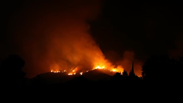 A raging hillside fire threatens a residential community.