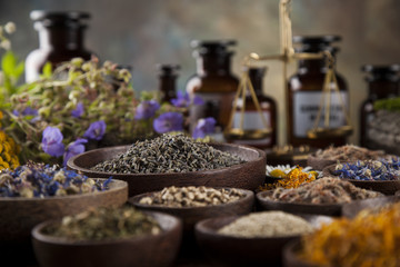 Healing herbs on wooden table, mortar and herbal medicine