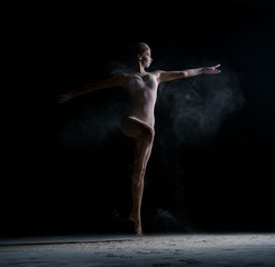 Dancer jumping gracefully in cloud of powder