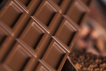 Chocolate bar, candy sweet, cacao beans and powder on wooden bac