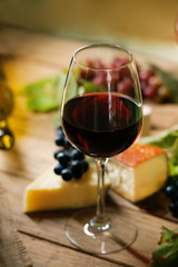 Glass of wine, grape and chesse on a table 