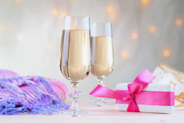Glasses of champagne with gift box and winter scarf