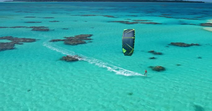 Aerial view young man kitesurfing in tropical blue ocean, extreme sport