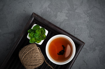 Black tea cup, succulent, twine