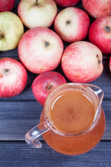 fresh squeezed apple juice in the pitcher on wooden table top view