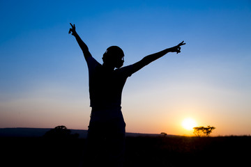 Fototapeta na wymiar Silhouette young woman with headphone on sunrise background.
