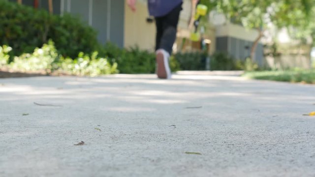 Low angle shot of a teenager picking up his skateboard and walking away.