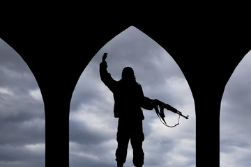 Silhouette of man holding rifle during dusk