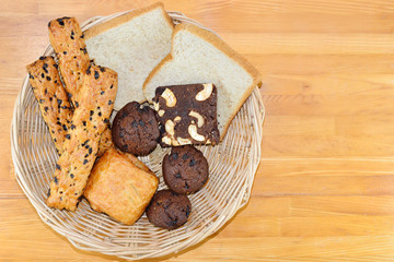 Bread in the basket on wooden table.