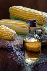 Fresh corn with bottle of oil