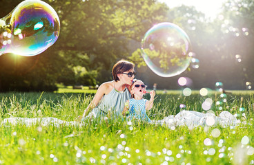 Mother and daughter family time, blowing soap-bubbles