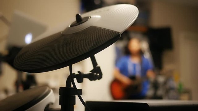 A close up view of a electronic cymbal being struck during band practice.