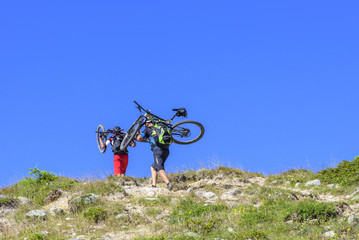mühsamer Aufstieg mit geschultertem Rad im Hochgebirge