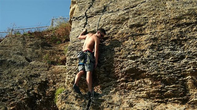 Muscular Climber Climbing Without Insurance On A Cliff