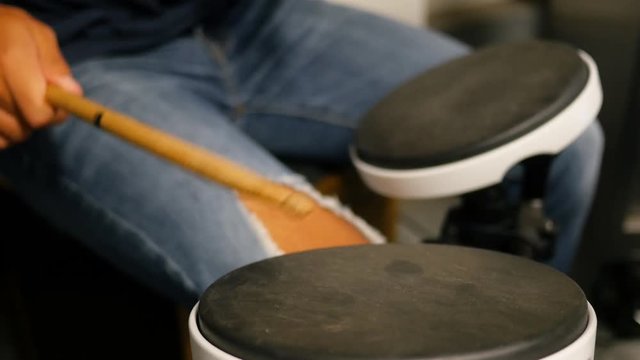 A young male drummer practicing on drum pads.