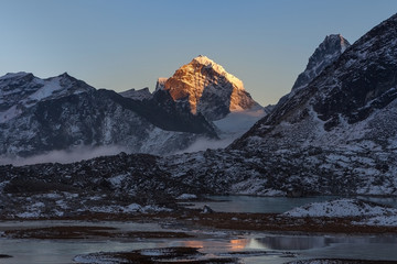 Schöne Berglandschaft im Himalaya, Nepal. Atemberaubende Hochlandlandschaft der Bergkette bei Sonnenuntergang und kleinen Moränenseen, die mit Eis bedeckt sind. Schneebedeckter Gipfel in großer Höhe.