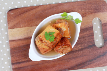 Gold bar soup as fried tofu wrap minced pork in soup and coriander .