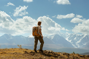 Naklejka premium Man stands on the mountains background