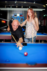 Fototapeta premium Beautiful couple flirting on a pool game