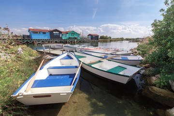 Naklejka premium petites barques colorés au port des salines sur l'ile d'oléron avec ses cabanes en bois