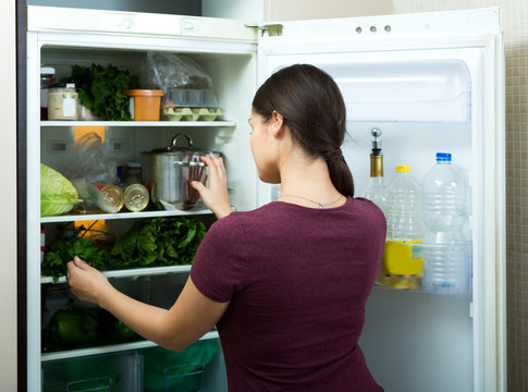 Positive Housewife Standing Near Filled Fridge